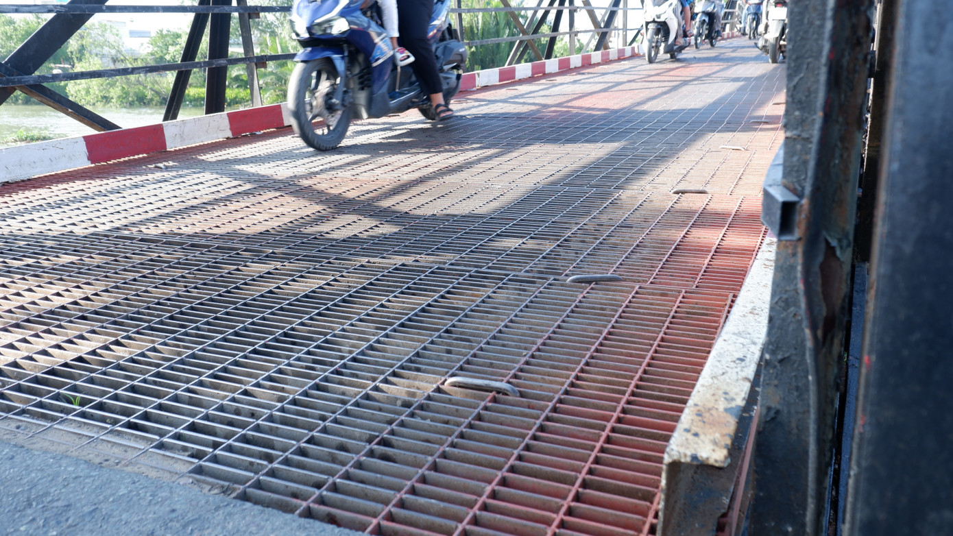 Mặt cầu ghép bởi các tấm sắt, khi xe chạy qua thường gây tiếng động lớn, rung lắc mạnh. Ảnh: Hữu Huy Mặt cầu ghép bởi các tấm sắt, khi xe chạy qua thường gây tiếng động lớn, rung lắc mạnh. Ảnh: Hữu Huy