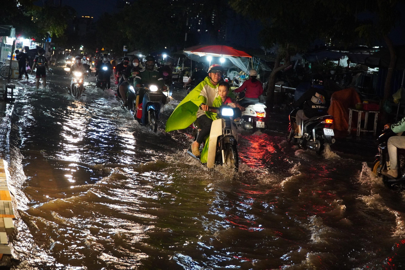 Người dân bì bõm lội nước về nhà sau giờ tan tầm.