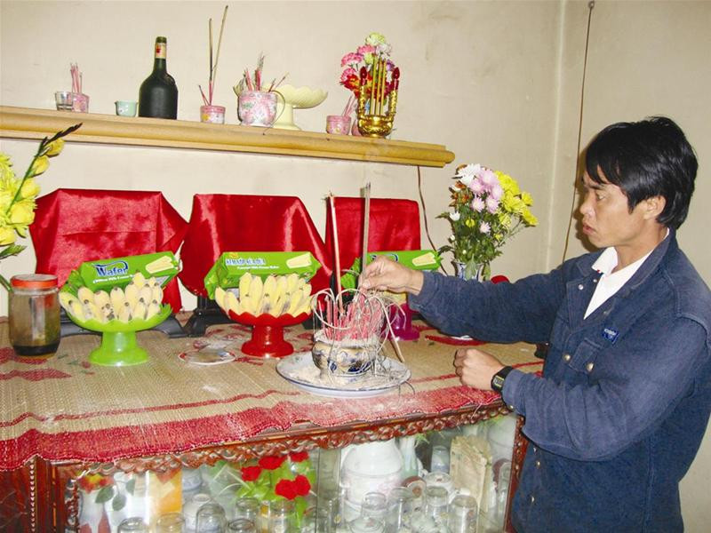 Anh Tạo bên bàn thờ vợ và con Anh Tạo bên bàn thờ vợ và con