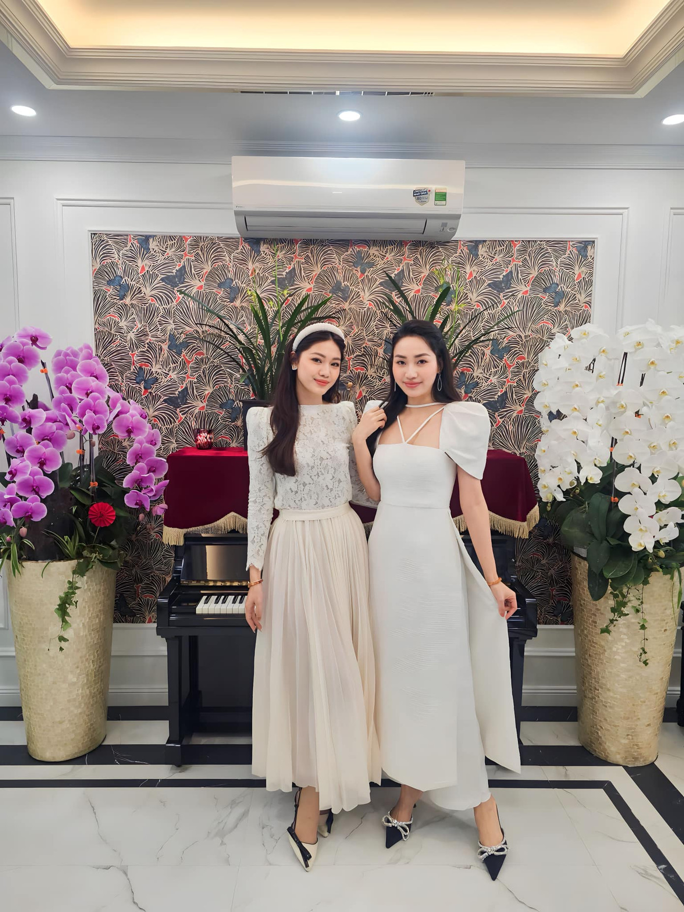 Á hậu Thanh Tú và chị gái Trà My cùng mặc áo dài trắng nền nã khi đi chúc Tết.