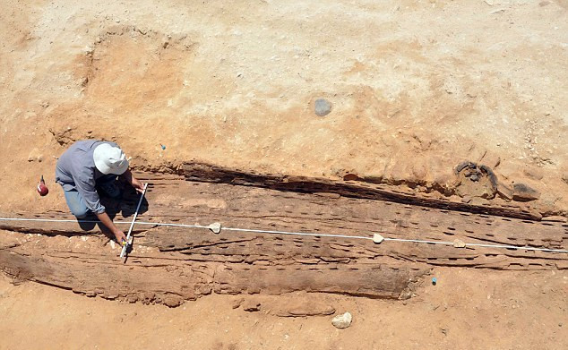 Các nhà khảo cổ đang đo đạc chiếc thuyền vừa được khai quật này