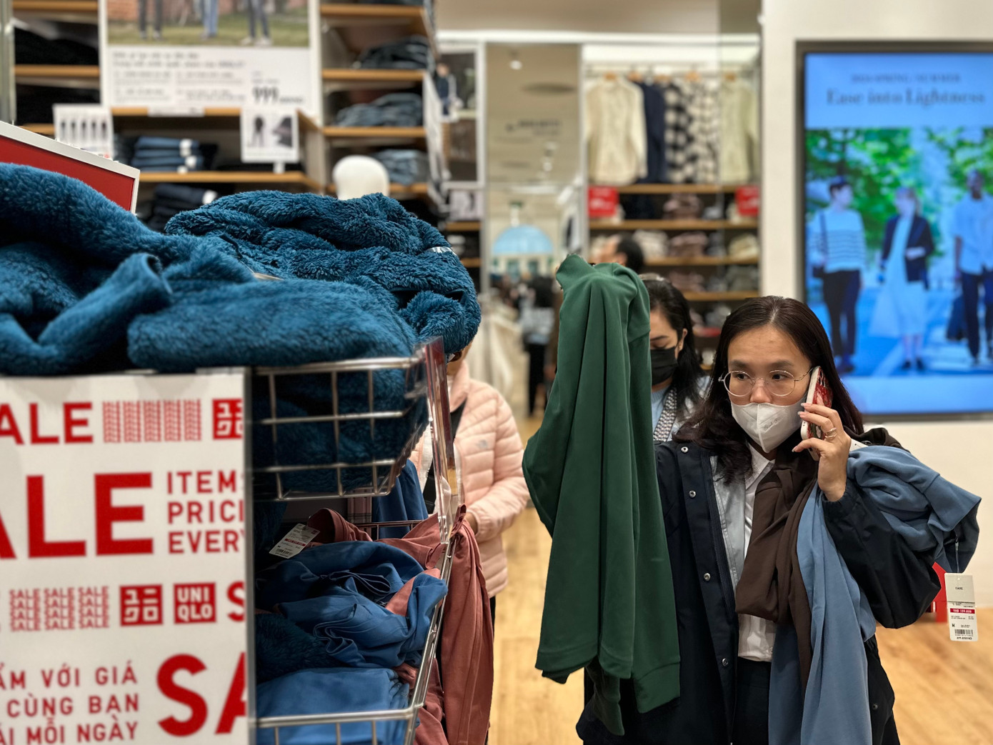 Biển giảm giá gắn khắp các quầy kệ, khách hàng vội vã chọn đồ. Không chỉ mua sắm cho bản thân, mà nhiều người còn tranh thủ sale lớn, dịp cuối năm sắm sửa quần áo Tết cho cả gia đình, người thân, chọn đồ qua điện thoại, gọi video để lựa đồ.