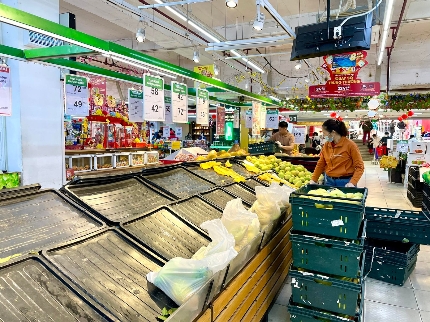 Đối lập với sự sôi động, hàng hoá đầy ắp của các chợ truyền thống, thì ngay trong sáng 30 Tết, một số siêu thị đã sớm hết hàng. Siêu thị ngưng nhập, tiếp thêm rau củ quả và một số mặt hàng tươi sống (ảnh: Phạm Tuyên)