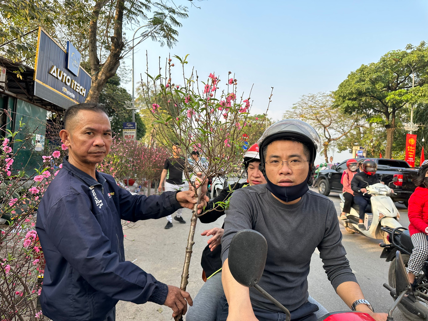 Những cây đào phai, đào bích từ làng đào Nhật Tân (Hà Nội) cũng nở rộ khoe sắc. Trong buổi chiều cuối tuần, nhiều người dân Thủ đô đã chọn được cành đào ưng ý. Sau một hồi mặc cả, anh Nguyễn Quang (đường Láng, Hà Nội) đã đồng ý trả 400.000 đồng để mang về nhà cành đào dáng huyền. "Kinh tế khó khăn, nhưng giá đào vẫn khá cao", anh Quang chia sẻ.