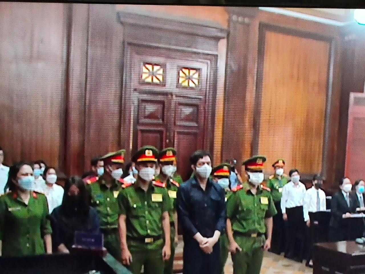 Hai bị cáo Thái, Trang (hàng đầu) tại phiên tòa. Ảnh chụp qua màn hình. Hai bị cáo Thái, Trang (hàng đầu) tại phiên tòa. Ảnh chụp qua màn hình.