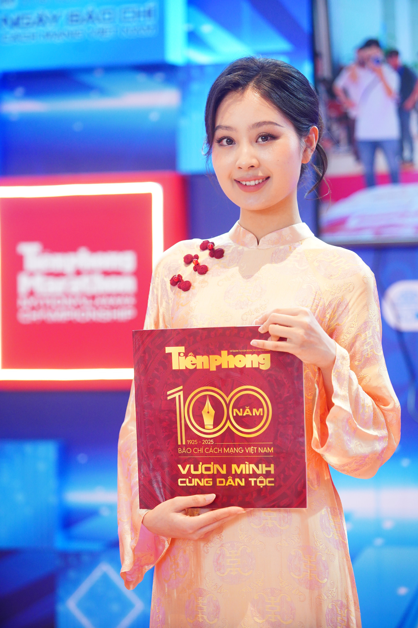 Người đẹp bên cạnh ấn phẩm kỷ niệm 100 năm Báo chí Cách mạng Việt Nam.