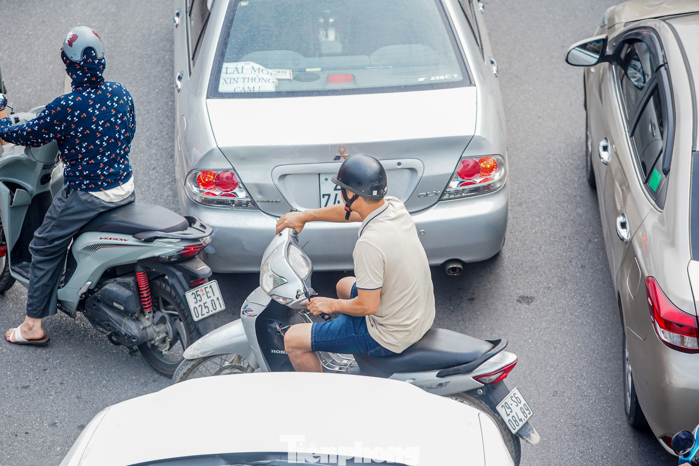 Xe máy luồn lách giữa hai ô tô. Xe máy luồn lách giữa hai ô tô.