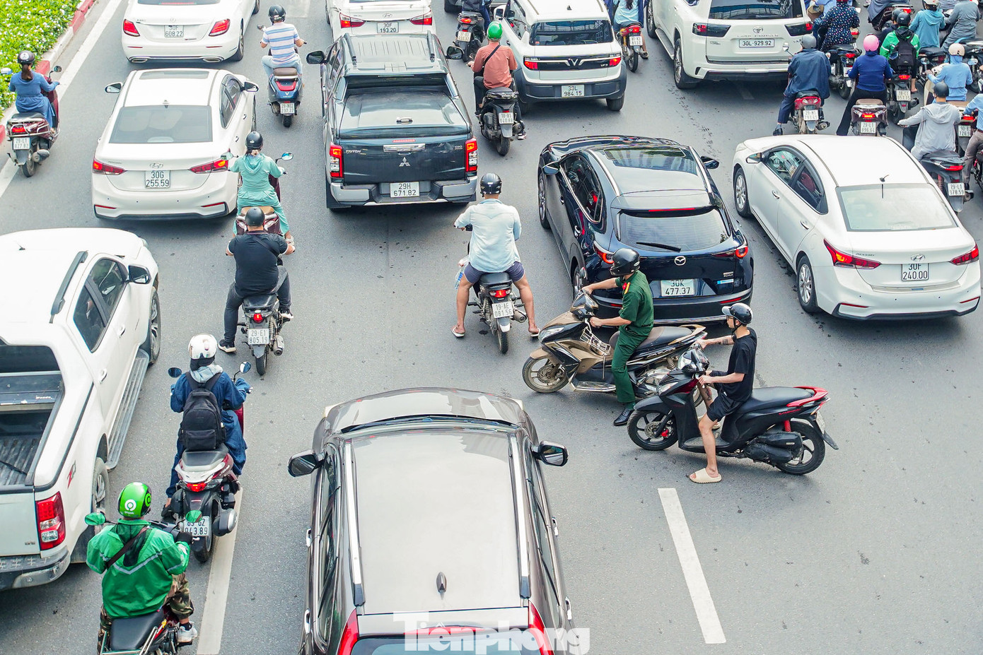 Các phương tiện xe máy lách qua các khu vực không gian nhỏ giữa các làn ô tô. Các phương tiện xe máy lách qua các khu vực không gian nhỏ giữa các làn ô tô.