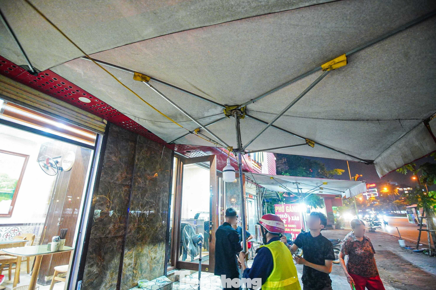 Ô dù dựng trên vỉa hè được yêu cầu tháo dỡ.