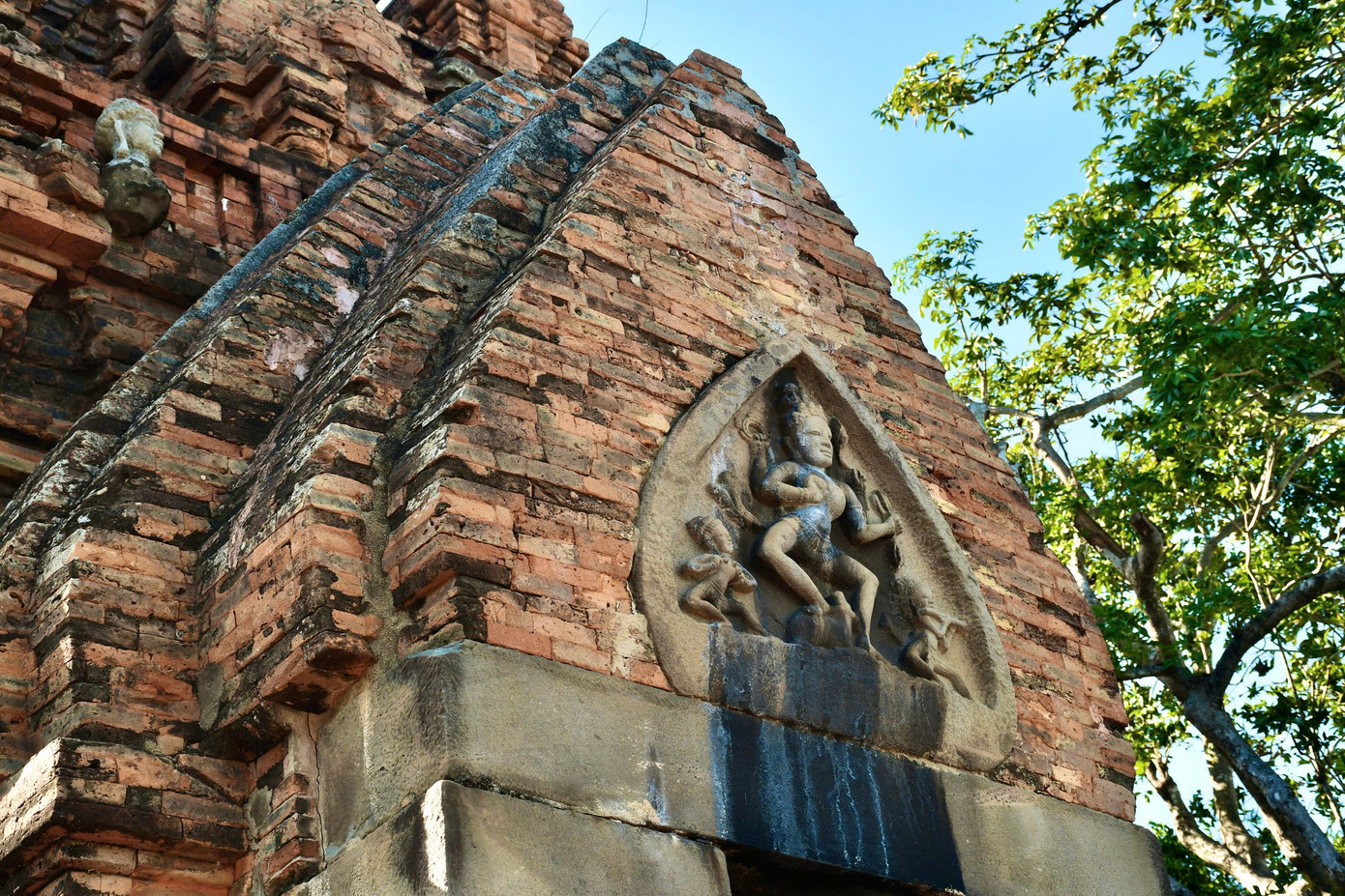 Trên vòm cửa tháp chính là tấm phù điêu đá hình lá, thể hiện thần Shiva với 4 cánh tay múa, hai nhạc công thổi sáo và chân phải Shiva đặt trên lưng bò thần Nandin. Phù điêu này có niên đại thế kỷ 11 và là một trong những tấm đẹp nhất của văn hóa Chămpa còn lưu giữ ở Việt Nam.