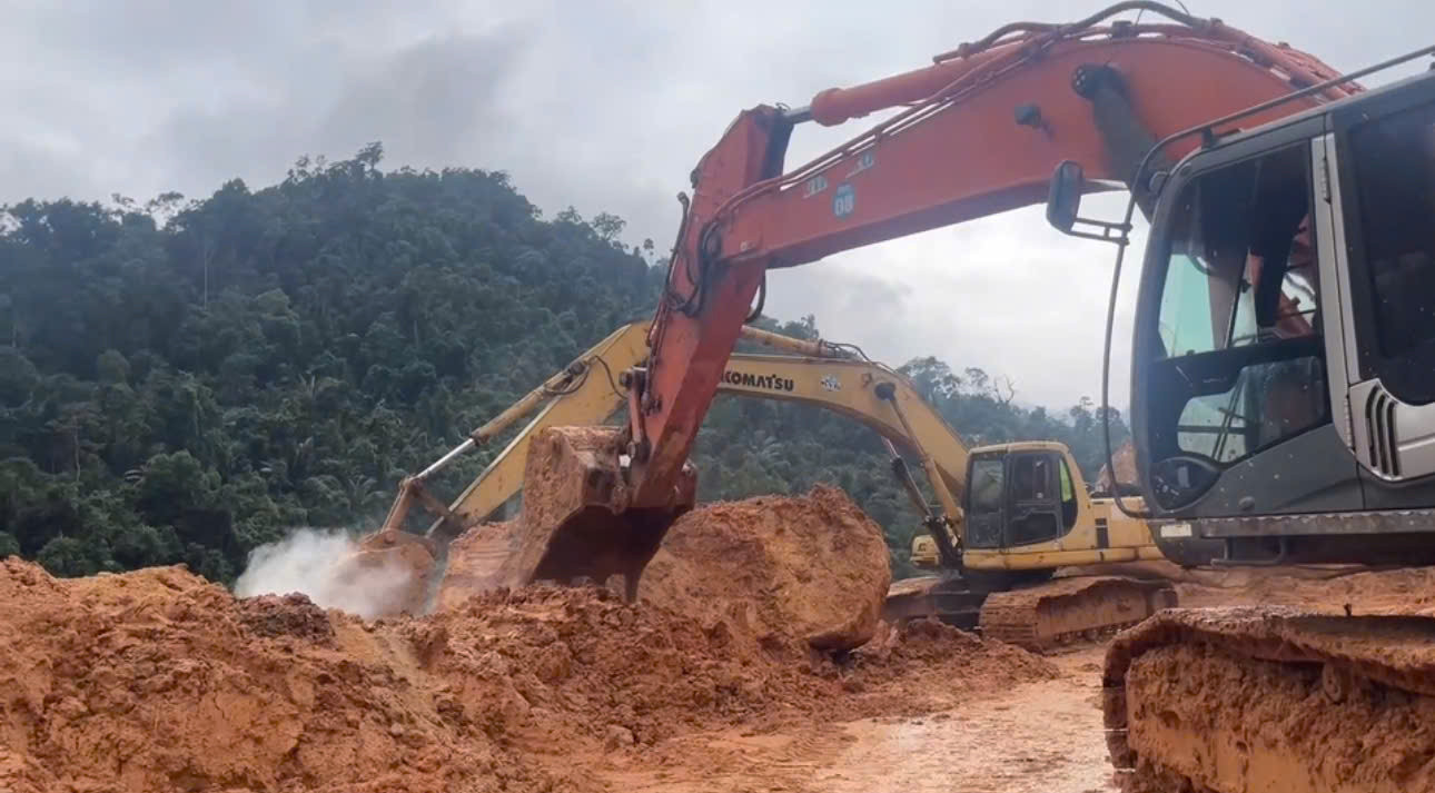 Lực lượng chức năng huy động máy móc, thiết bị xử lý những khối đá gây cản trở giao thông trên tuyến đường quốc lộ 27C (đoạn đèo Khánh Lê).