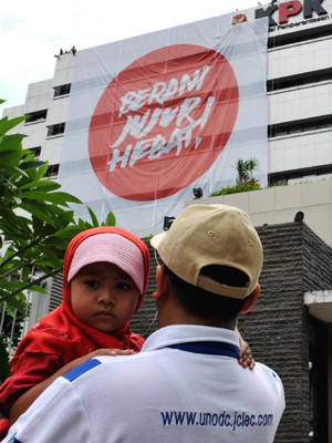 Người dân Indonesia xem khẩu hiệu chống tham nhũng tại trụ sở KPK hôm 25-11. Ảnh: Xinhua