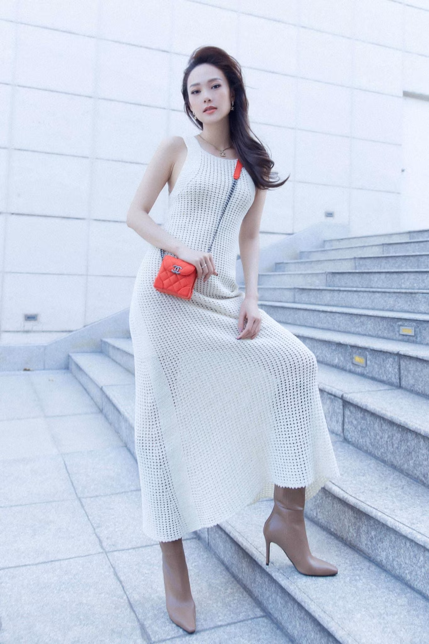 Chiếc váy trắng đơn điệu nhưng khi kết hợp với boots và túi xách lại giúp Minh Hằng trông cá tính và sành điệu.