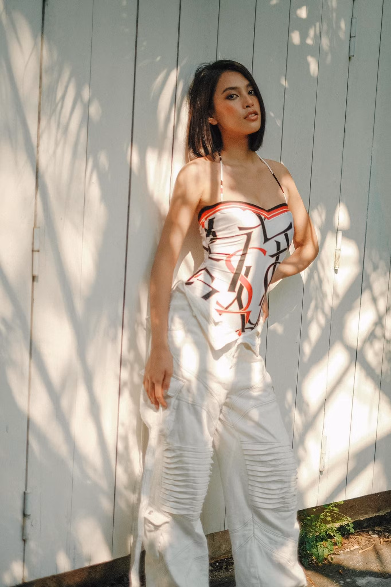 Tiểu Vy kết hợp "khăn áo" hai dây với quần ống suông cạp cao làm nên bộ đồ street style vừa sành điệu, hợp mốt lại vừa dễ dàng tránh nắng.
