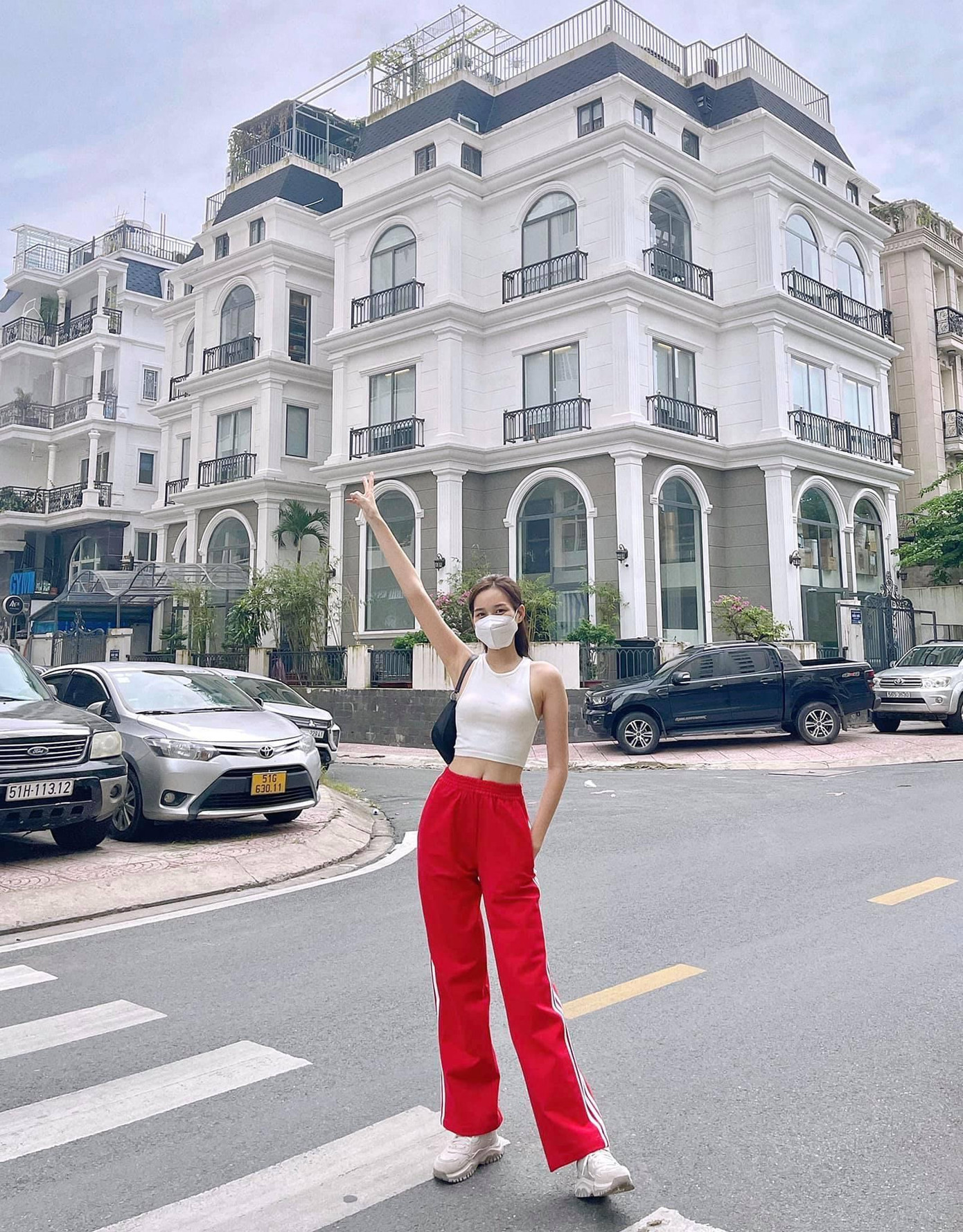 Hoa hậu Đỗ Thị Hà khỏe khoắn, năng động khi phối áo croptop sát nách trắng với quần ống rộng thể thao màu đỏ nổi bật.