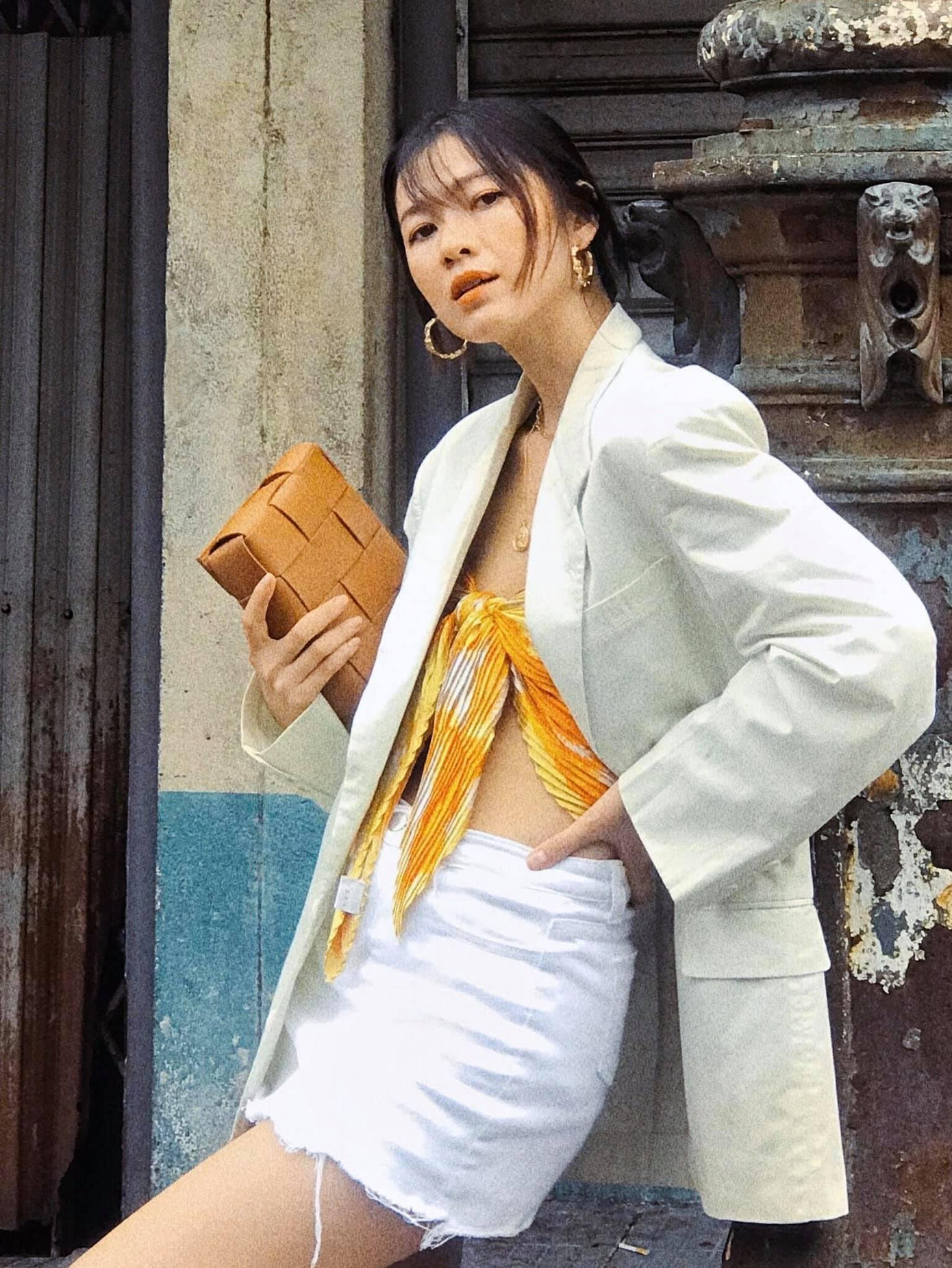 Bằng việc mix bên trong chiếc blazer màu be chiếc khăn quấn thành áo màu vàng bắt mắt, và diện chân váy ngắn trắng, cô nàng đã có ngay bộ trang phục vừa hack tuổi lại quyến rũ.