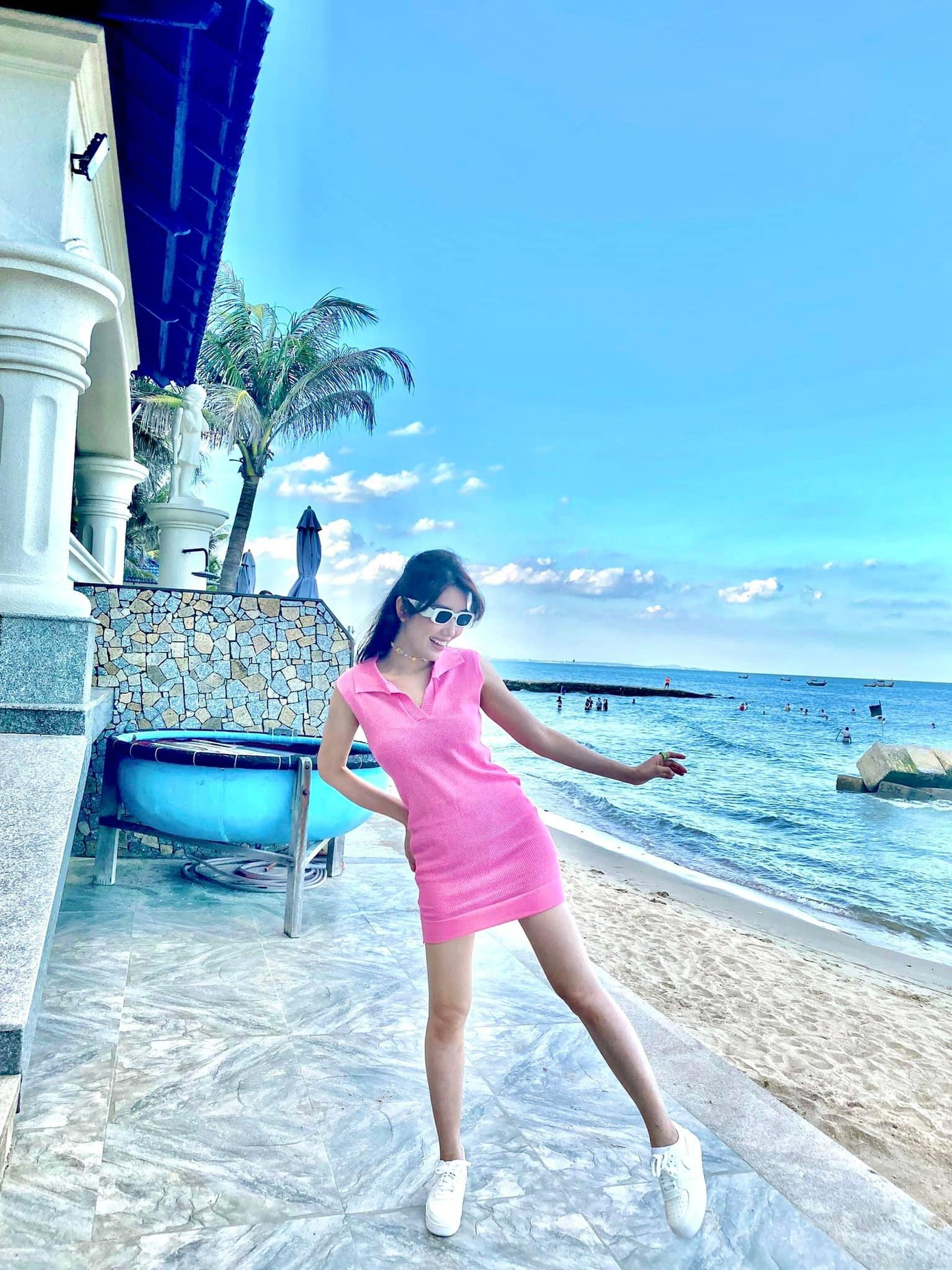 Thúy Ngân năng động khi phối váy hồng với giày thể thao và kính mắt.