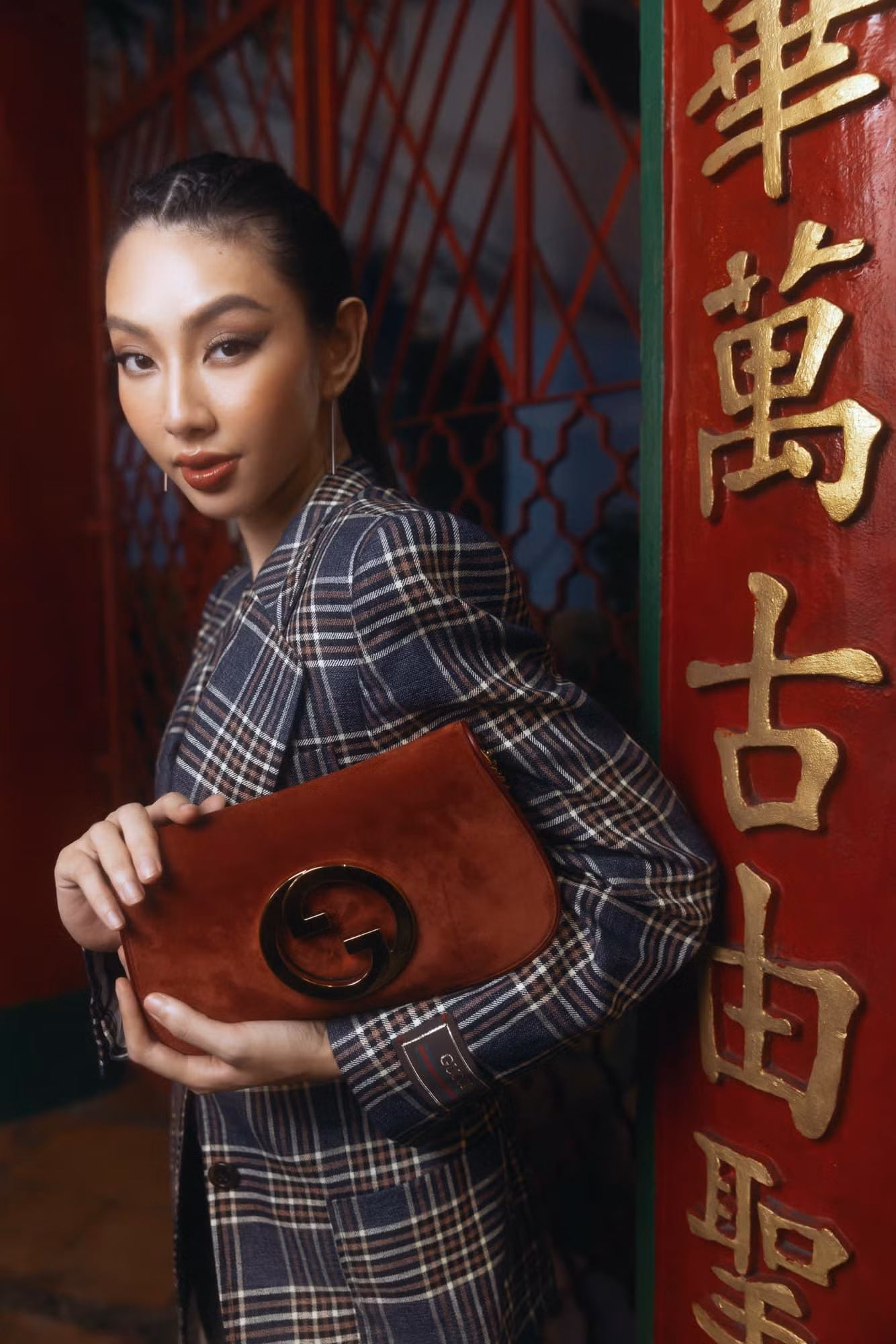 Thùy Tiên kết hợp chiếc túi Dior màu đỏ sang chảnh, cá tính với set blazer kẻ để tăng phần năng động và mang hơi hướng cổ điển.