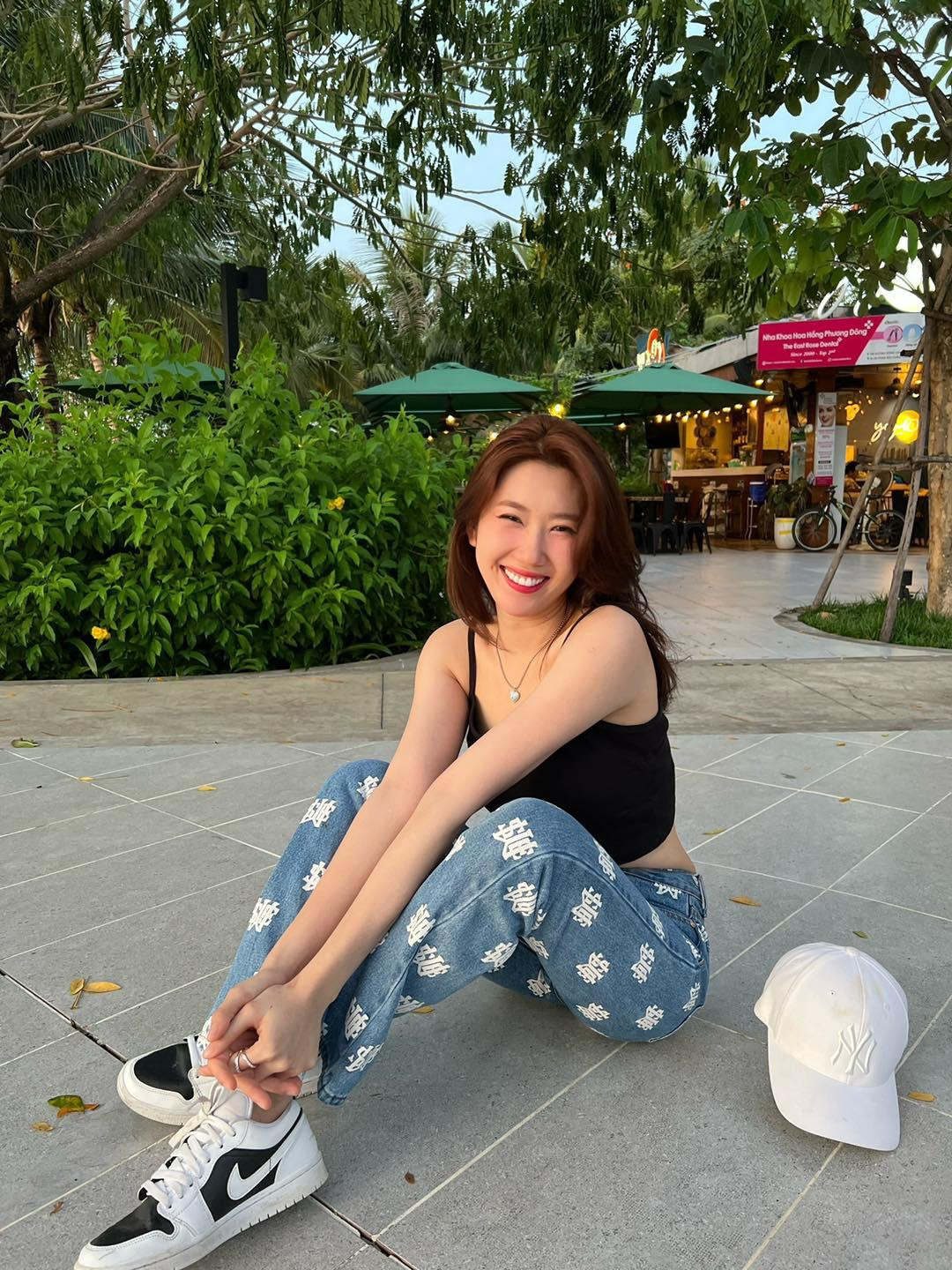 Phối đồ với áo hai dây đen đơn điệu, Thúy Ngân chọn một chiếc quần jeans họa tiết kết hợp cùng giày thể thao để tăng sự năng động, thoải mái.