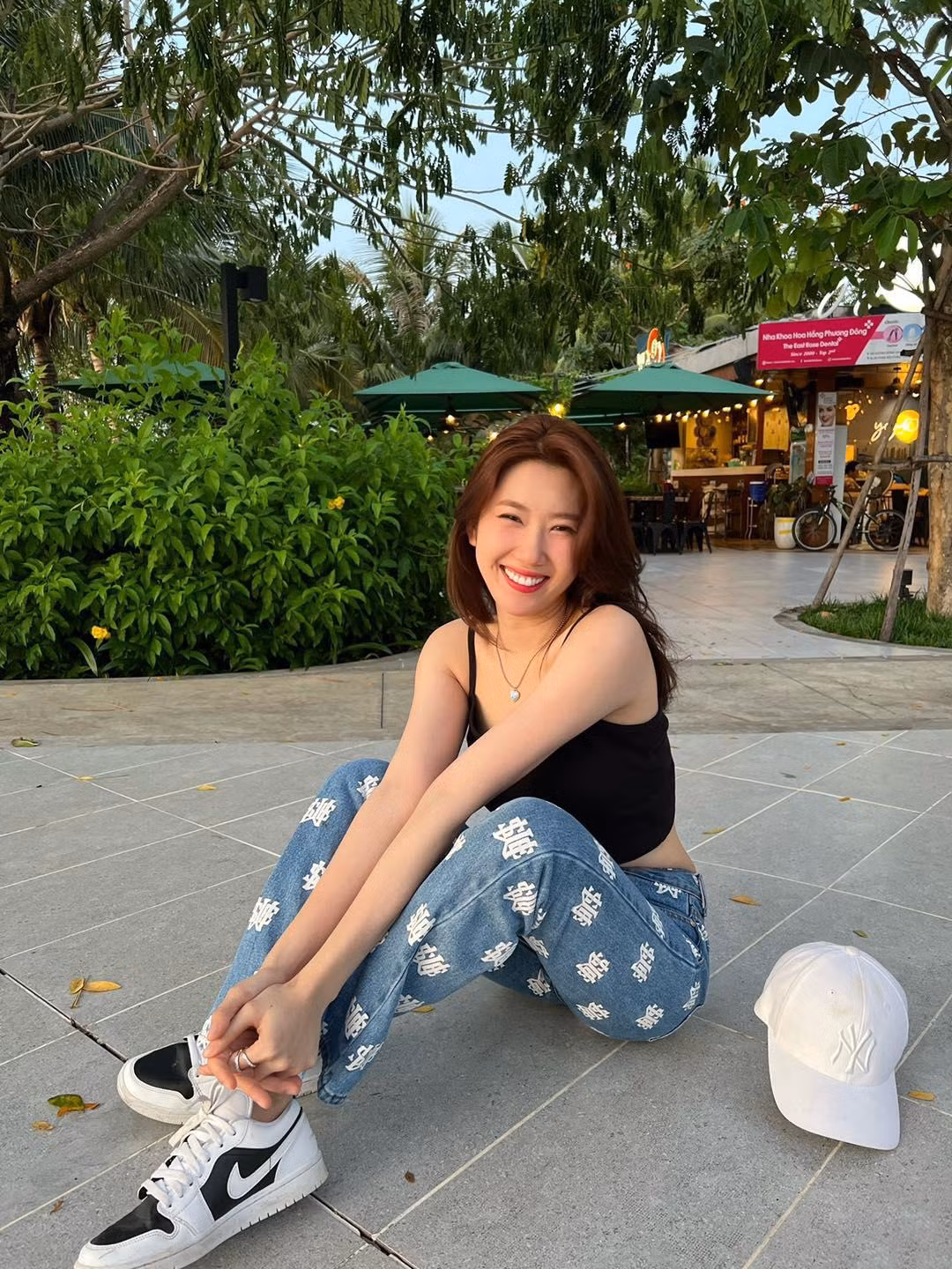 Phối đồ với áo hai dây đen đơn điệu, Thúy Ngân chọn một chiếc quần jeans họa tiết kết hợp cùng giày thể thao để tăng sự năng động, thoải mái.