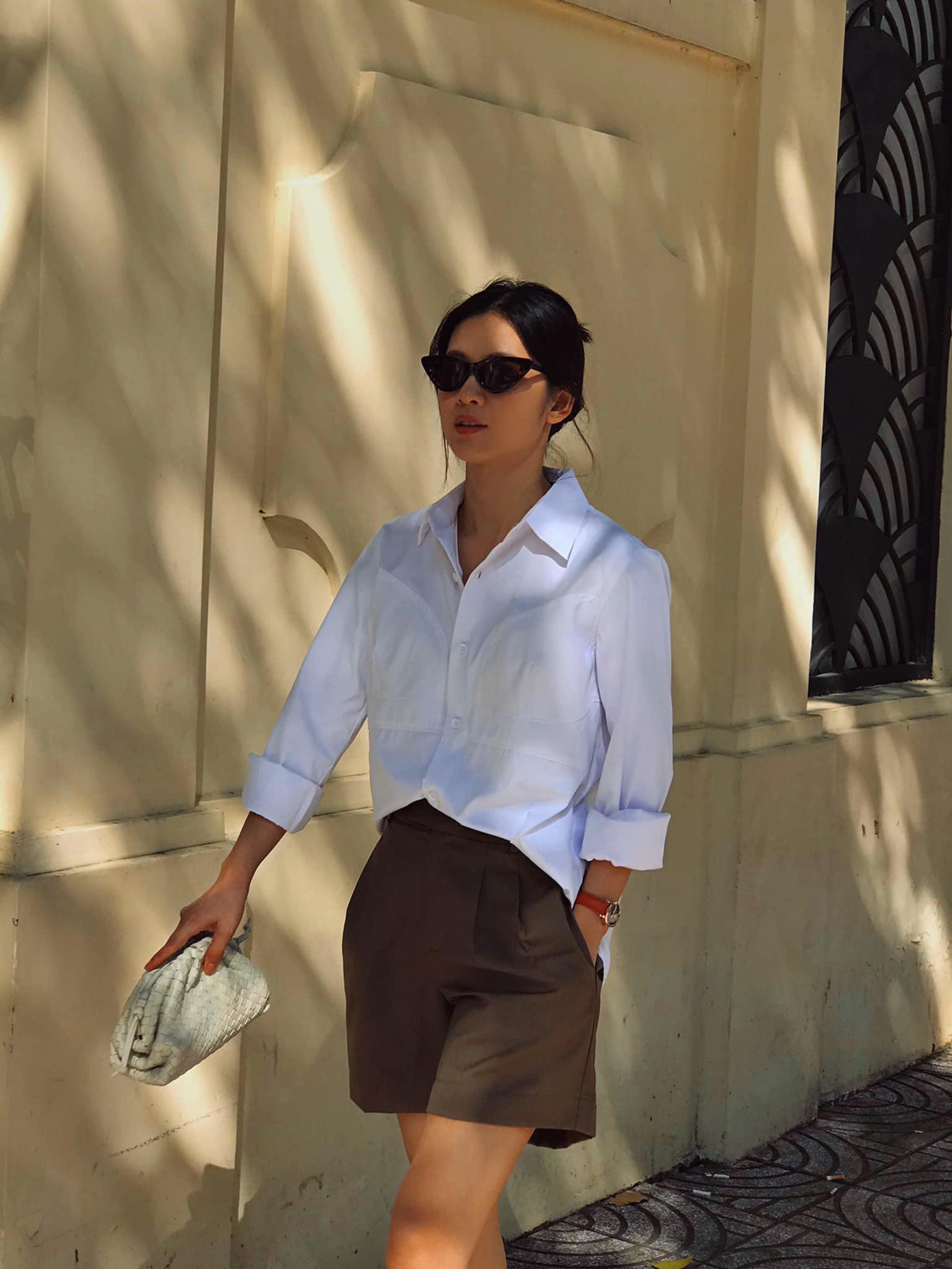 Sơ mi trắng là item không thể thiếu trong tủ đồ của hội chị em. Để set đồ bớt đơn điệu, Oanh Kiều lựa chọn kết hợp cùng quần short màu nâu tây và các phụ kiện.