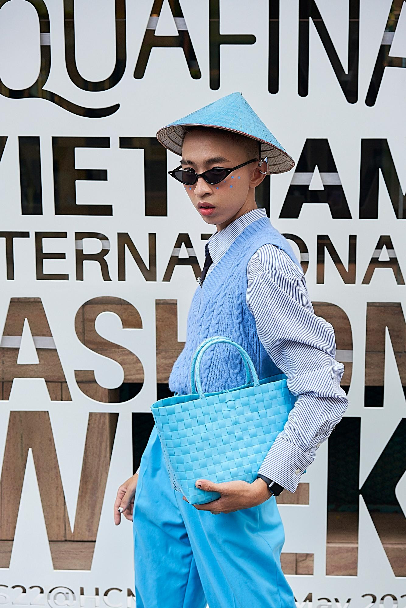 Xuất hiện với chiếc sơ mi trắng phối cùng gile xanh, Hoàng Nghiêm chọn cho mình phong cách hiện đại kết hợp với những phụ kiện mang chất liệu dân gian như nón lá, túi đan.