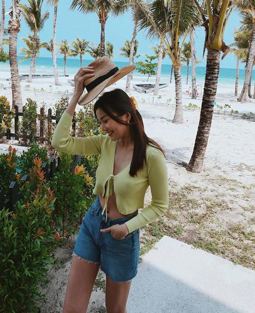 Kết hợp áo len móc với quần short jeans khi đi biển, Thanh Hằng trẻ trung như Gen Z.
