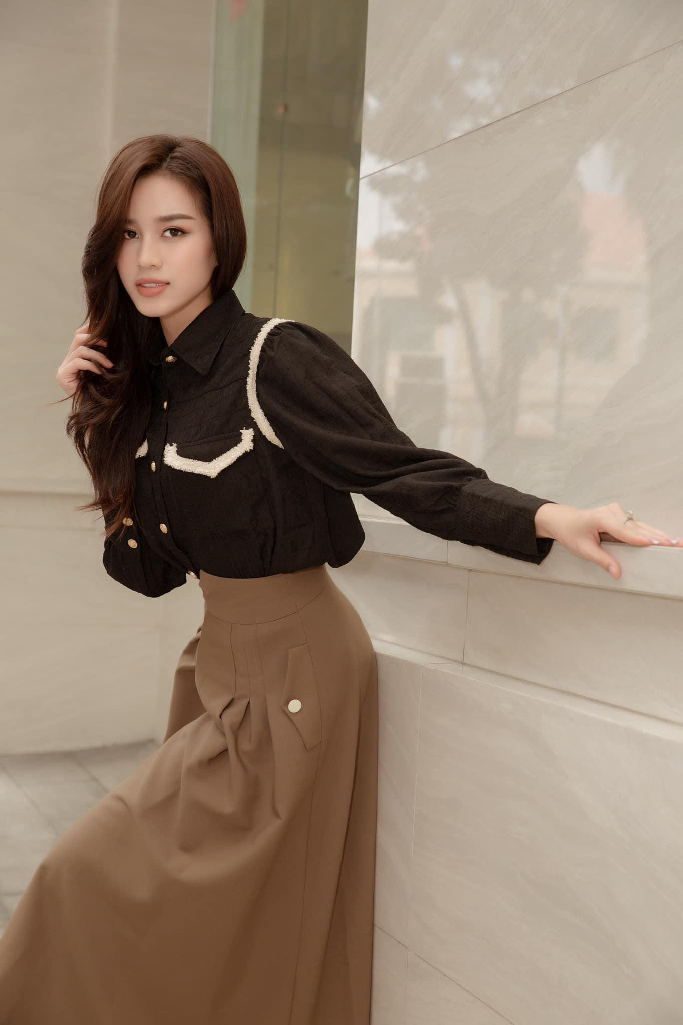 Đỗ Thị Hà trở nên bắt mắt hơn khi phối áo sơ mi tay dài với chân váy cùng tone màu trầm.