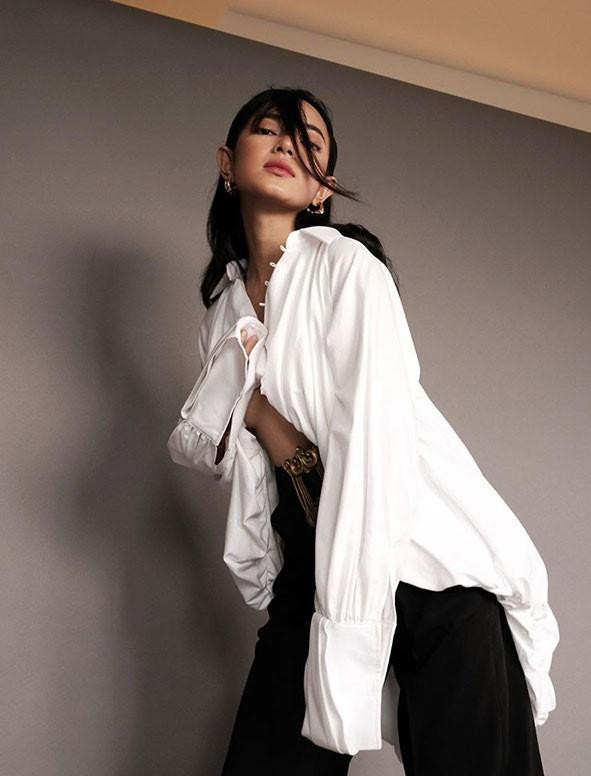 Châu Bùi diện sơ mi trắng đơn giản với quần jeans đen nhưng vẫn thần thái.