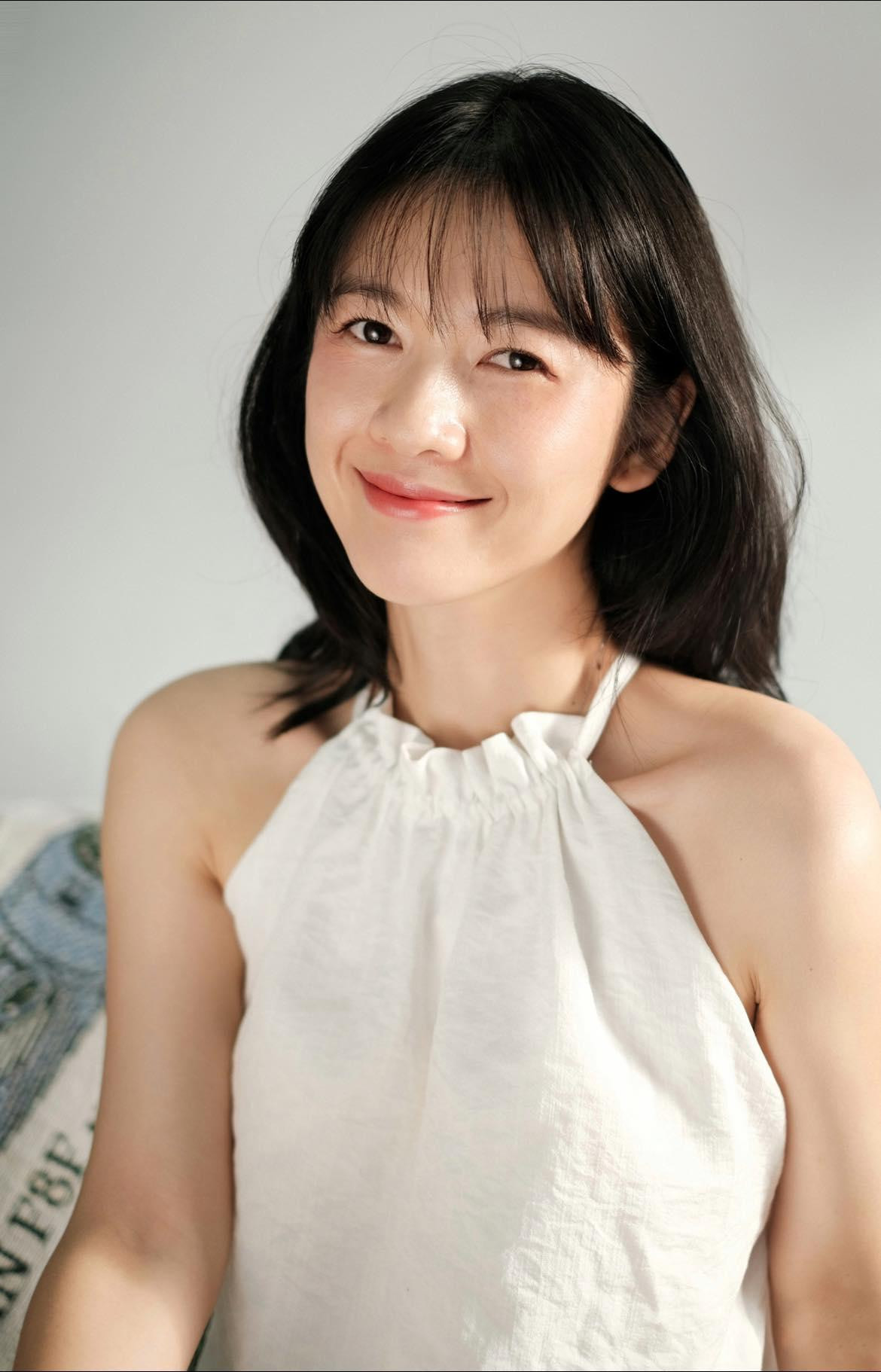 Chiếc váy trắng cổ yếm giúp Oanh Kiều để lộ phần xương quai xanh quyến rũ.