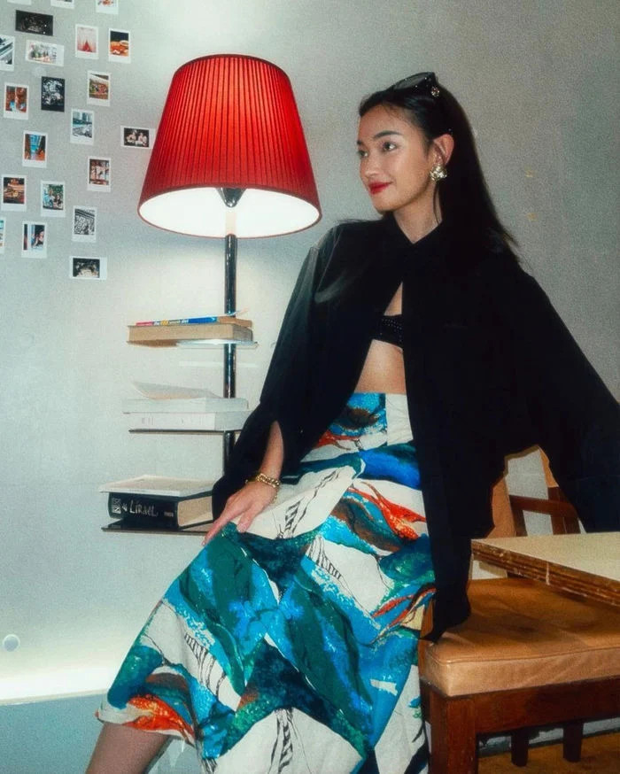 Châu Bùi chọn phối áo sơ mi đen với chân váy họa tiết vừa nổi bật lại độc đáo.