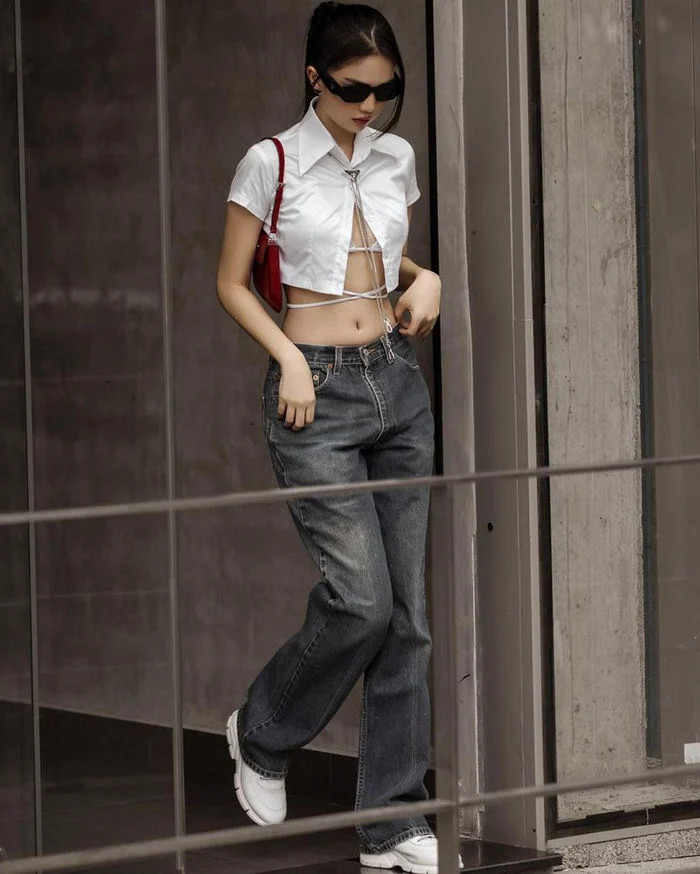 Chọn phối áo sơ mi đóng cúc "hờ" bên ngoài nội y kết hợp cùng quần jeans ống suông, Ngọc Trinh thu hút ánh nhìn khi lên đồ xuống phố.