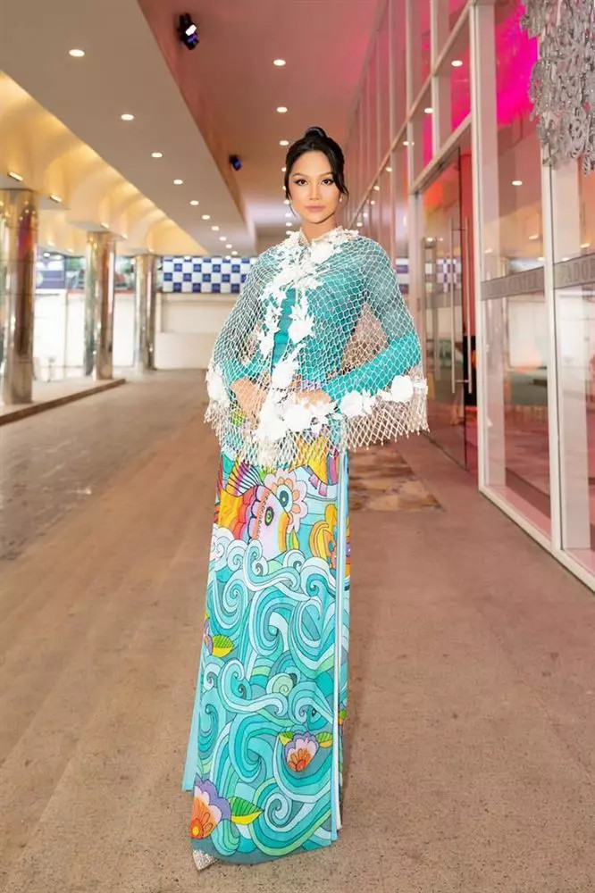 H'Hen Niê gây ấn tượng bởi bộ trang phục độc đáo khi diện áo choàng dạng lưới màu trắng bên ngoài chiếc áo dài truyền thống. H'Hen Niê gây ấn tượng bởi bộ trang phục độc đáo khi diện áo choàng dạng lưới màu trắng bên ngoài chiếc áo dài truyền thống.