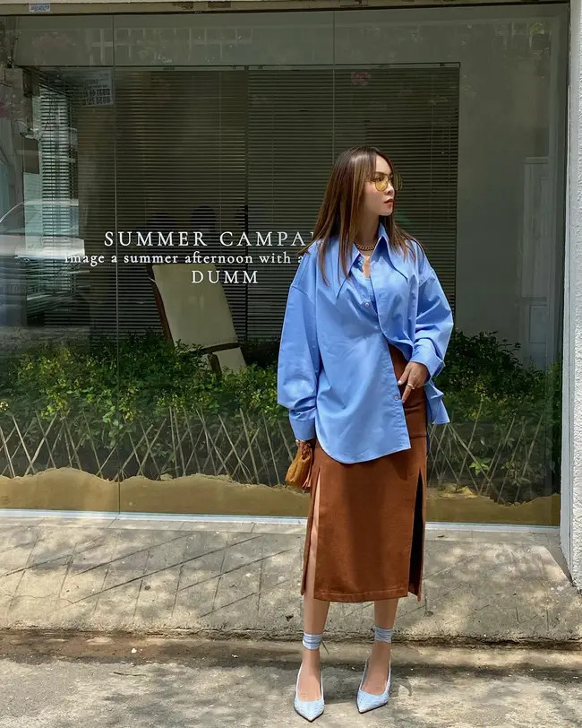 Nữ ca sĩ ghi điểm khi diện sơ mi dáng rộng đóng cúc hờ với chân váy nâu xẻ cao vừa lịch sự, trang nhã lại không kém phần sang trọng.