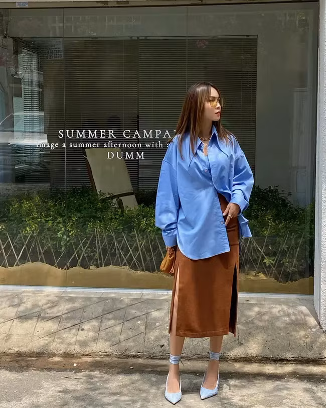 Nữ ca sĩ ghi điểm khi diện sơ mi dáng rộng đóng cúc hờ với chân váy nâu xẻ cao vừa lịch sự, trang nhã lại không kém phần sang trọng.