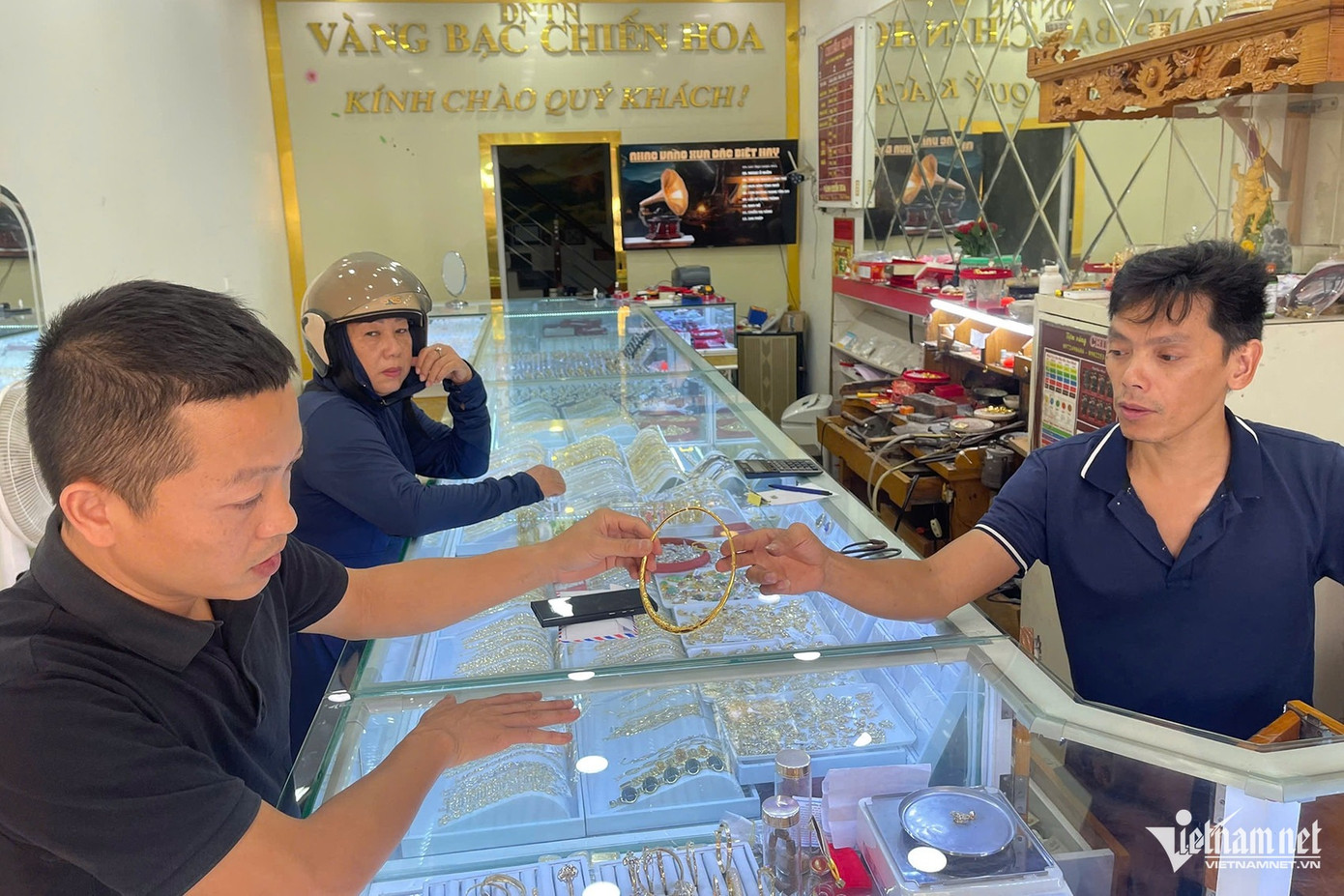 Ông Duy (bên phải) những ngày gần đây chỉ bán được vàng trang sức cho khách nhưng không nhiều. Ảnh: Phạm Công