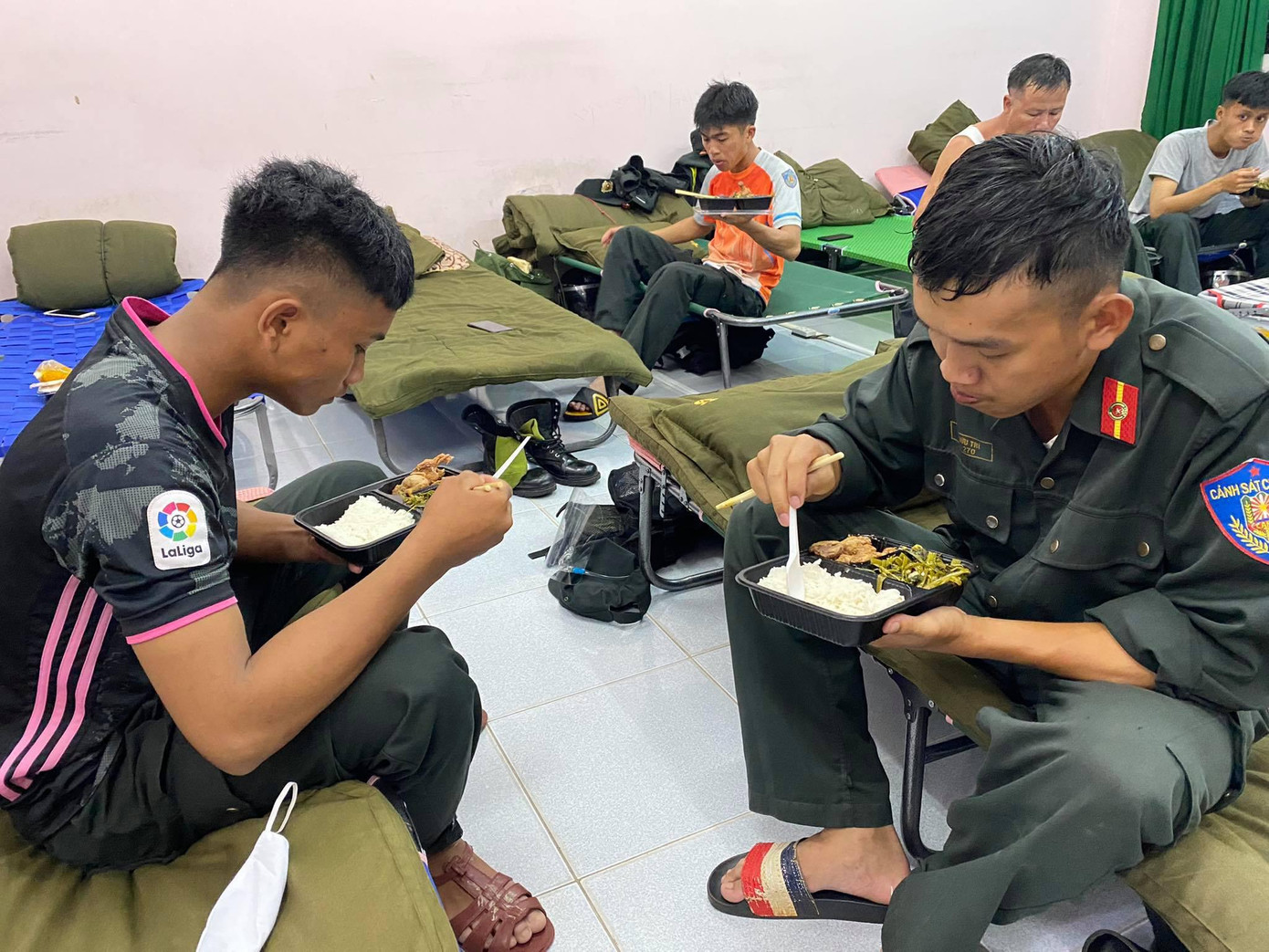 Theo đó, Tiểu đoàn 3 của Trung đoàn CSCĐ Tây Nguyên đã ngay lập tức về các chốt kiểm soát trên địa bàn TPHCM để nhận nhiệm vụ. Tiểu đoàn 1 và tiểu đoàn 2 tranh thủ sắp xếp chỗ ăn, nghỉ dã chiến trước khi tăng cường xuống các phường, xã để áp dụng biện pháp mạnh “ai ở đâu ở đó", quản lý giãn cách, phong toả nghiêm ngặt; bảo đảm an sinh xã hội, lo ăn, ở cho người dân, bảo đảm an ninh trật tự, an toàn, an dân. Trong ảnh: Các chiến sĩ ăn vội bữa tối trước khi lên đường nhận nhiệm vụ mới.