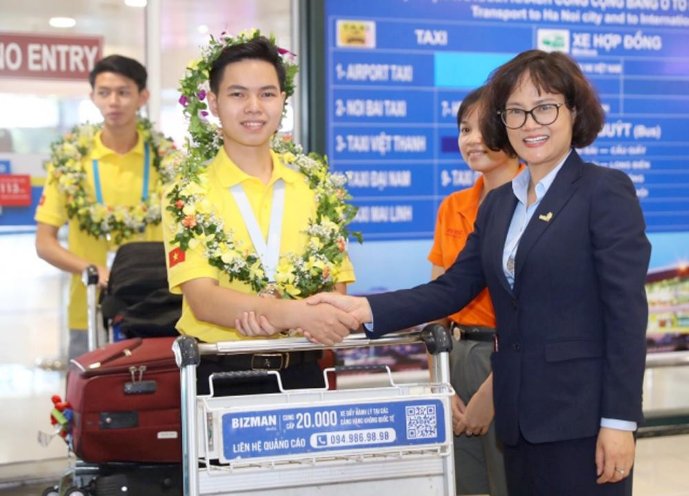 Phó Tổng cục trưởng Tổng cục GDNN Nguyễn Thị Việt Hương tặng hoa chúc mừng thí sinh Nguyễn Xuân Thái - HCB nghề Tiện CNC