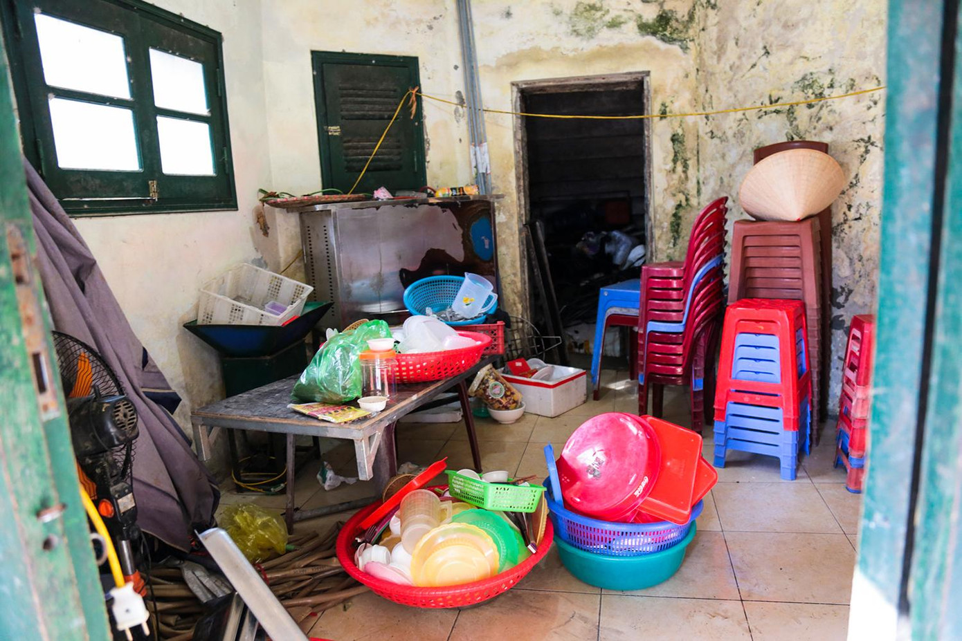 Bàn ghế, bát đũa, ô che, chậu cùng nhiều vật dụng khác để ở tầng 1 căn biệt thự.