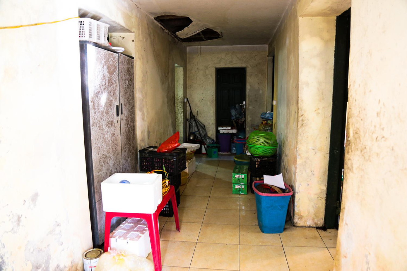 Lối vào chính giữa ngôi nhà cũng xếp đầy đồ vật của những người bán hàng trên vỉa hè.