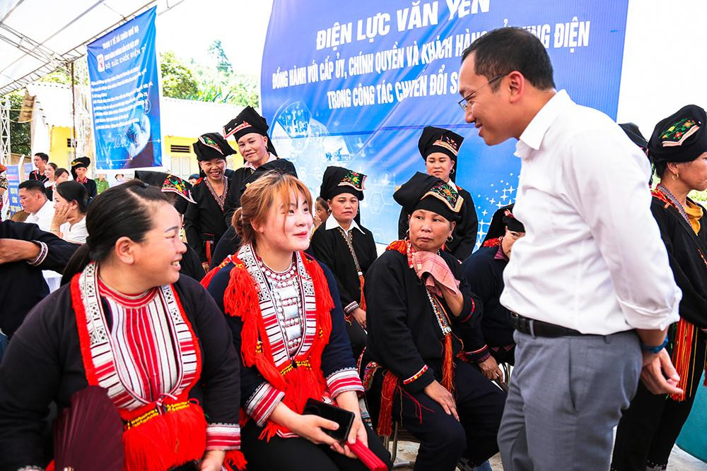 Giám đốc Sở Thông tin truyền thông tỉnh Yên Bái, ông Hoàng Minh Tiến trao đổi với thanh niên thôn Khe Bành về việc cài đặt các ứng dụng trên điện thoại thông minh.