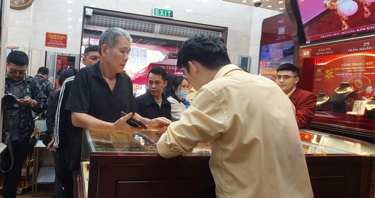 Nhân viên cửa hàng vàng phát số thứ tự cho khách hàng đến mua bán vàng. Nhân viên cửa hàng vàng phát số thứ tự cho khách hàng đến mua bán vàng.