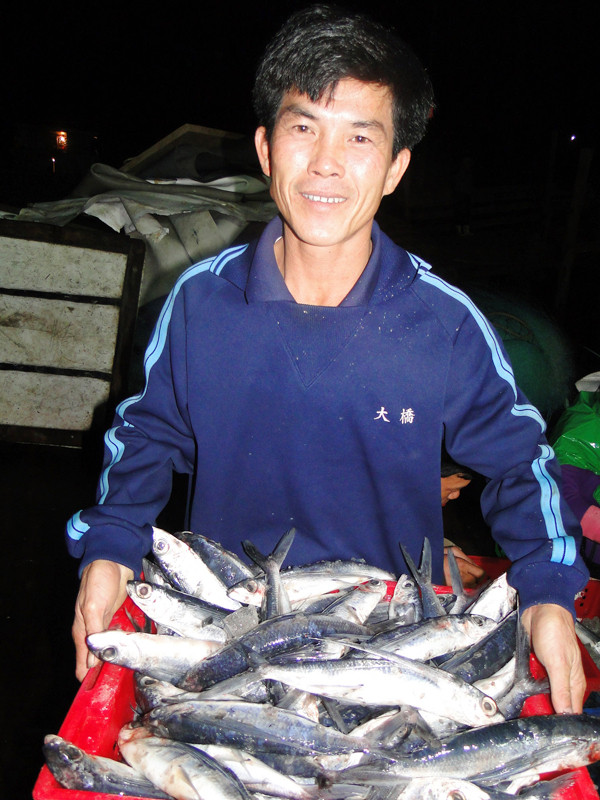 Thuyền trưởng Can cười tươi với rổ cá chuồn Hoàng Sa. Thuyền trưởng Can cười tươi với rổ cá chuồn Hoàng Sa