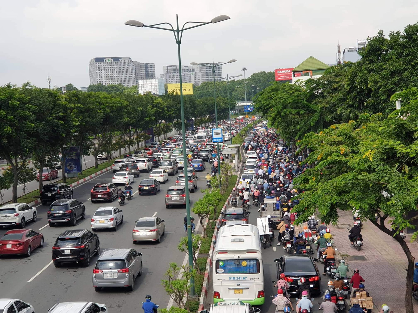 Ô tô xếp hàng trên đường Phạm Văn Đồng. Trong khi đó, để né kẹt xe, nhiều người đã điều khiển xe máy di chuyển vào làn ô tô khiến giao thông càng thêm rối loạn.