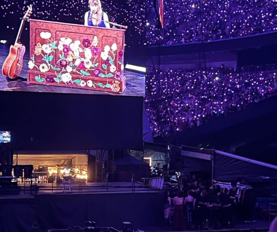 Các nhân viên đứng sát nhau sau hậu trường cùng nghe Taylor hát Long Live.