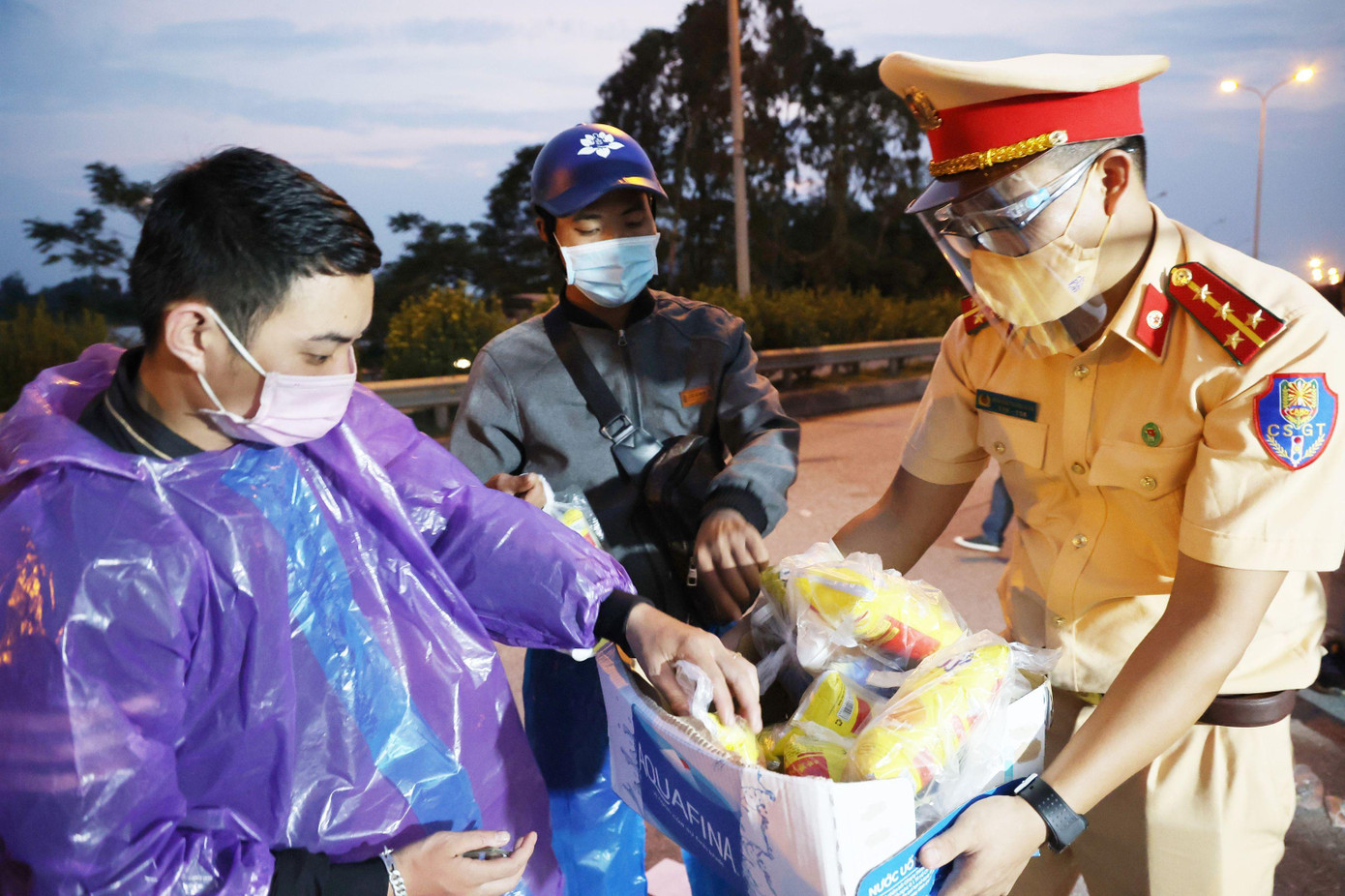 Cảnh sát giao thông Hà Nội hỗ trợ đồ ăn, nước uống cho người dân đi từ vùng dịch phía Nam về quê ngày 6/10/2021. Ảnh: NAM NGUYỄN