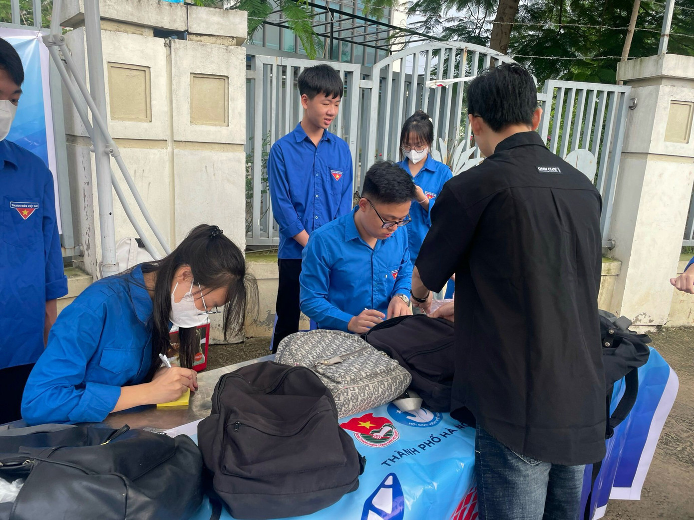 Các tình nguyện viên hỗ trợ thí sinh cất đồ trước khi vào phòng thi Các tình nguyện viên hỗ trợ thí sinh cất đồ trước khi vào phòng thi