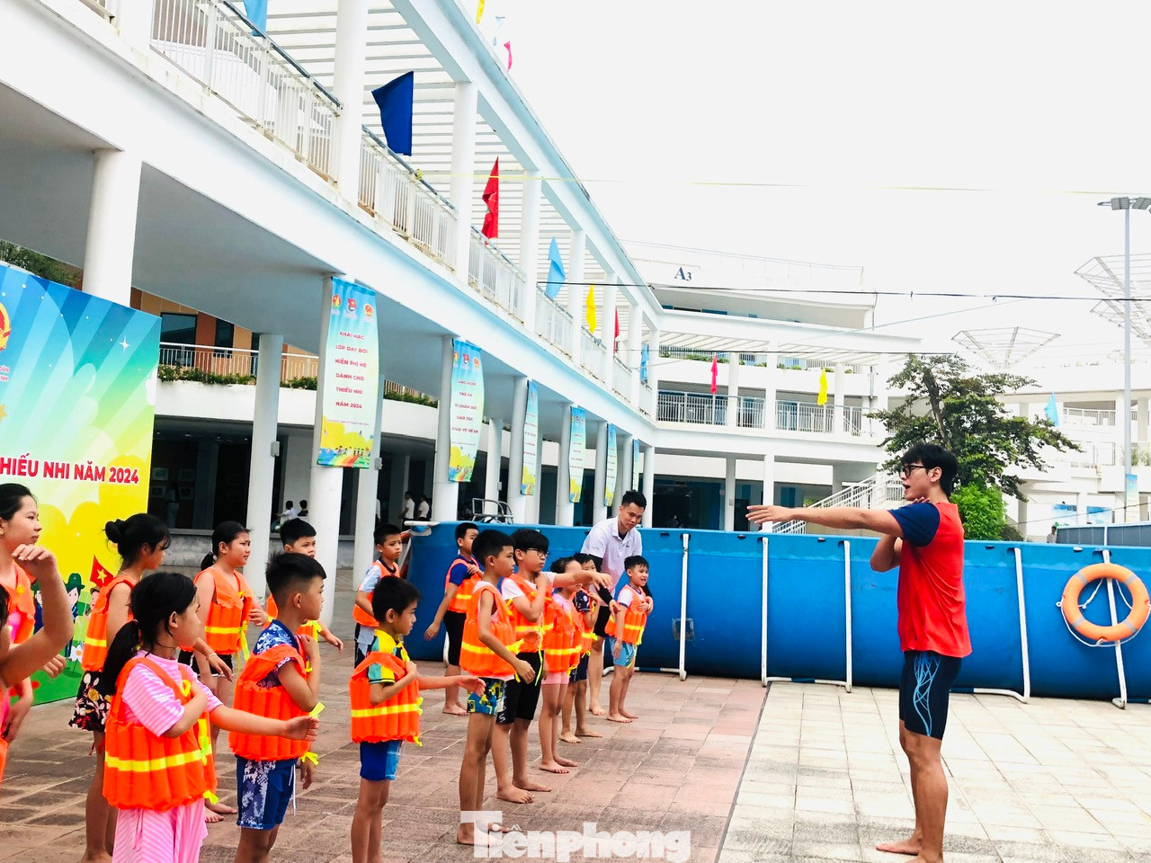 Kình ngư Hoàng Quý Phước hướng dẫn các em mặc áo bơi, khởi động trước khi xuống bể bơi Kình ngư Hoàng Quý Phước hướng dẫn các em mặc áo bơi, khởi động trước khi xuống bể bơi