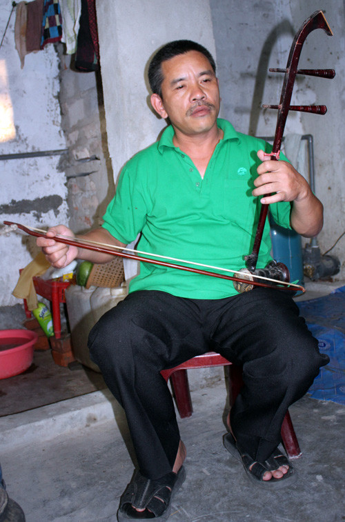 Nhạc công Đỗ Sĩ Lương chơi đàn bên góc bếp