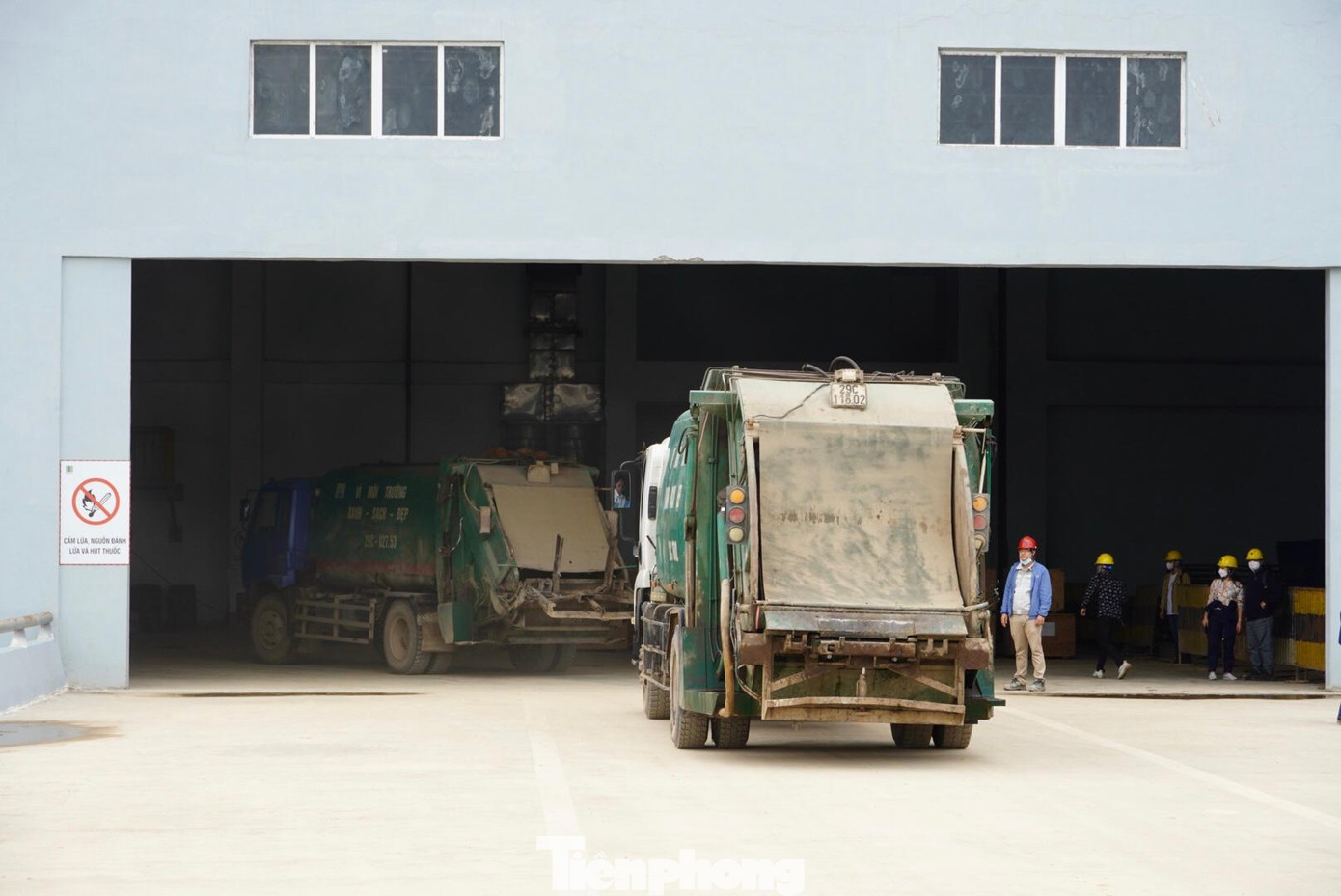 Các xe rác chở rác đổ vào buồng chứa rác